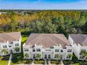 Scenic aerial view of modern townhomes, lush landscaping, and surrounding treeline at 17230 Blessing Dr, Clermont, FL 34714