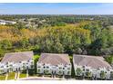 Aesthetic aerial view of modern townhomes showcasing lush landscaping and tree coverage at 17230 Blessing Dr, Clermont, FL 34714