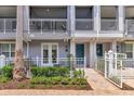 Charming exterior of a light gray townhome with a white picket fence and a vibrant teal door at 1767 Piedmont Pl, Lake Mary, FL 32746