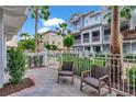 Inviting patio space with comfortable seating, surrounded by lush landscaping and a white picket fence at 1767 Piedmont Pl, Lake Mary, FL 32746