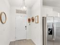 Bright entryway featuring tile floors, white walls, and a stainless steel refrigerator at 17985 Adrift Rd, Winter Garden, FL 34787