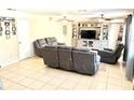 Bright living room featuring tile floors, gray furniture, and a TV entertainment center for cozy gatherings at 213 S Lake Pleasant Rd, Apopka, FL 32703