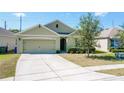 View of single story home with neutral exterior, trimmed shrubs, two-car garage and concrete driveway at 2312 Rose Blvd, Winter Haven, FL 33881