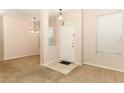 Entryway with tile flooring, beige carpet, chandelier, and white front door at 2530 San Jacinto Cir # 2530, Sanford, FL 32771