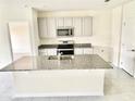 Modern kitchen with granite countertops, stainless steel appliances, and central island with sink at 2637 Rowan St, Tavares, FL 32778