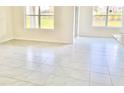 Bright living room features tile floors, neutral walls, and plenty of natural light from large windows at 2637 Rowan St, Tavares, FL 32778