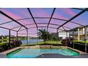 Relaxing screened-in pool overlooking a serene lake, perfect for outdoor enjoyment and entertaining at 2704 Gorst Rd, Winter Garden, FL 34787