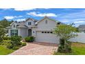 Beautiful single-Gathering home featuring a brick driveway, manicured landscaping, and a convenient two-car garage at 4296 Mirror Ct, Clermont, FL 34714