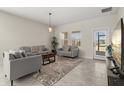 Inviting living room features neutral paint, tile floors, modern furniture and lots of natural light at 4350 Verde Valley Ln, Kissimmee, FL 34746