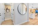Bright hallway featuring modern finishes, a round mirror, and an open view into the adjacent dining area at 5156 Gardenrow Dr, St Cloud, FL 34772