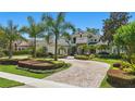 Beautiful circular driveway leading up to a stunning home with lush landscaping and mature palm trees at 5550 Osprey Isle Ln, Orlando, FL 32819