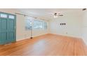 Bright living room featuring hardwood floors, large windows, and a classic ceiling fan at 735 Baltimore Dr, Orlando, FL 32810
