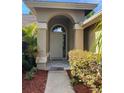 Covered front door entrance with tiled floor and garden to the side at 840 Lake Jackson Cir, Apopka, FL 32703
