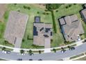 Aerial view of a well-maintained property with a dark roof, solar panels, and manicured lawns at 8768 Sonoma Coast Dr, Winter Garden, FL 34787