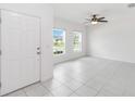 Bright, airy living room features neutral walls, tile flooring, and ample natural light from the surrounding windows at 928 Avenal Ln, Davenport, FL 33837