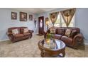 Inviting living room featuring tile floors, natural light, and comfortable leather seating at 929 Monroe Harbor Pl, Sanford, FL 32773