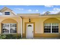 Close-up of front door with decorative glass, sidelight, and trimmed window with shutters at 13241 Fountainbleau Dr, Clermont, FL 34711