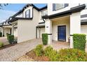 Charming townhome with blue door, manicured landscaping, and brick paved driveway at 10374 Park Commons Dr, Orlando, FL 32832
