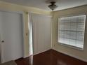Bright room with sliding glass door, window, and cherry-look floors, offering a cozy living space at 1079 S Hiawassee Rd # 1121, Orlando, FL 32835
