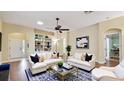 Staged living room with hardwood floors, bright light, bookshelves, and comfortable seating at 1156 Brandy Lake View Cir, Winter Garden, FL 34787