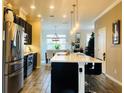 Bright, modern kitchen features stainless steel appliances, an island with seating, and pendant lighting at 11746 Water Run Aly, Windermere, FL 34786