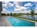 A refreshing pool with a serene waterfront view creates a perfect outdoor oasis at 13864 Destin Beach Ln, Orlando, FL 32827