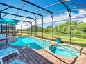 Relaxing screened-in pool area with a spa, comfortable lounge chairs, and a serene view at 16604 Caribbean Breeze Way, Clermont, FL 34714