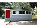 Home's exterior featuring gray siding, vibrant red door, updated windows and concrete steps at 232 W Lafayette St, Winter Garden, FL 34787