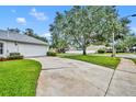 Long driveway leading to a two-car garage, surrounded by green lawns and mature trees at 288 Englenook Dr, Debary, FL 32713
