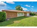 Inviting one-story home featuring a classic red tile roof, brick accents, a front lawn, and a two-car garage at 3108 Troy Dr, Orlando, FL 32806