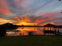Beautiful lake view at sunset with a dock and gazebo, reflecting vibrant colors in the tranquil water at 3108 Troy Dr, Orlando, FL 32806