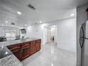 Bright open concept kitchen with stainless appliances, granite countertops, with an adjacent bathroom and door access at 3120 Ginger Cir, Orlando, FL 32826