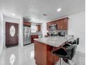 Modern kitchen featuring granite countertops, stainless steel appliances, breakfast bar and tile flooring at 3120 Ginger Cir, Orlando, FL 32826