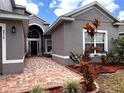 Charming front entrance with brick pathway and colorful landscaping at 3579 Maple Ridge Loop, Kissimmee, FL 34741