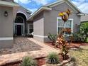 Beautiful front entrance with brick pathway and colorful landscaping at 3579 Maple Ridge Loop, Kissimmee, FL 34741