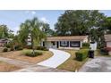 Charming single-story home with a curved driveway, lush landscaping, and a well-maintained lawn at 4015 Kirkland Blvd, Orlando, FL 32811