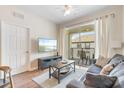 Comfortable living room with balcony access, wood floors, and a flat screen television at 4024 Breakview Dr # 40604, Orlando, FL 32819