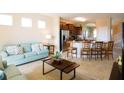 Cozy living room featuring a comfortable light-blue sofa and an open layout to the adjacent kitchen at 4405 Acorn Ct, Davenport, FL 33837