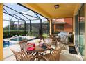 Inviting screened patio with dining table, chairs, and stainless steel grill, perfect for outdoor entertaining at 4405 Acorn Ct, Davenport, FL 33837