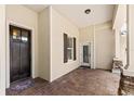 Inviting covered front porch with stone columns, brick pavers, and dark wood front door at 508 Yellow Submarine Ct, Groveland, FL 34736