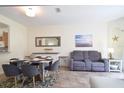 Dining area with a table set for six, seamlessly blending into the living room at 626 Verona Ave, Davenport, FL 33897