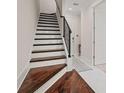 Elegant staircase with hardwood treads, white risers, and black iron railing at 654 Mariposa St, Orlando, FL 32801