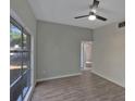Neutral bedroom featuring new light grey paint, laminated flooring, ceiling fan and a large window at 819 Edgewater Dr, Eustis, FL 32726