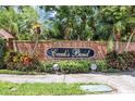 Entrance to the Creek's Bend neighborhood with brick wall and lush landscaping at 1039 Whispering Cv, Casselberry, FL 32707
