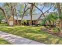 Charming brick home with mature trees, well-manicured lawn, and lush landscaping at 1039 Whispering Cv, Casselberry, FL 32707