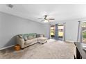 Cozy living room with plush carpet, ceiling fan, and sliding glass doors to the outdoors at 1107 Monroe Ave, St Cloud, FL 34769
