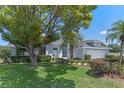 Beautiful home with a lush green lawn, mature trees, and a well-manicured garden at 11705 Binfield Ct, Orlando, FL 32837