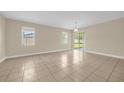 Open-concept living area featuring neutral paint, tiled floors and access to the backyard at 14517 Black Lake Preserve St, Winter Garden, FL 34787