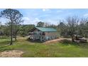 Exterior view with balconies overlooking the lawn, a green roof, and ample space at 1526 Maytown Rd, Oak Hill, FL 32759