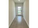 Bright foyer featuring neutral tiling and a glass-paneled front door allowing natural light to flood the space at 1904 Diamond Head Cir, Lake Hamilton, FL 33851